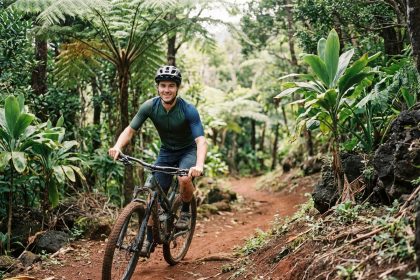 Jeune homme en vélo de montagne dans une forêt tropicale